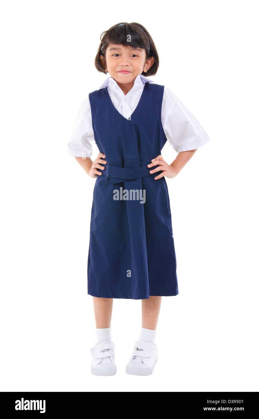 Siete años niña de la escuela del Sudeste Asiático en uniforme escolar, fullbody sobre fondo blanco. Foto de stock