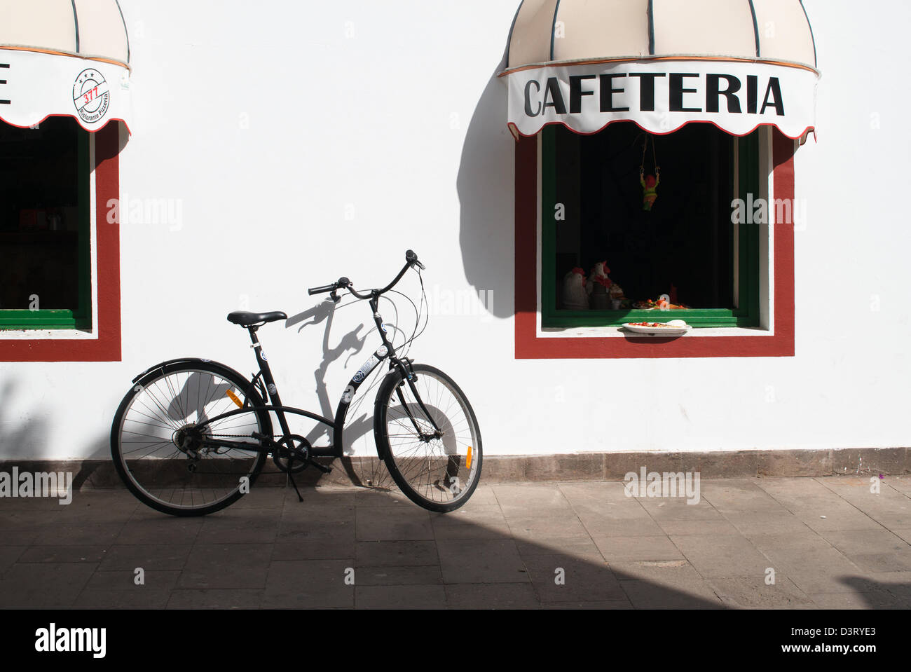 Bicicleta estacionada fuera de cafetería en el Puerto de Mogan, Gran Canaria Foto de stock