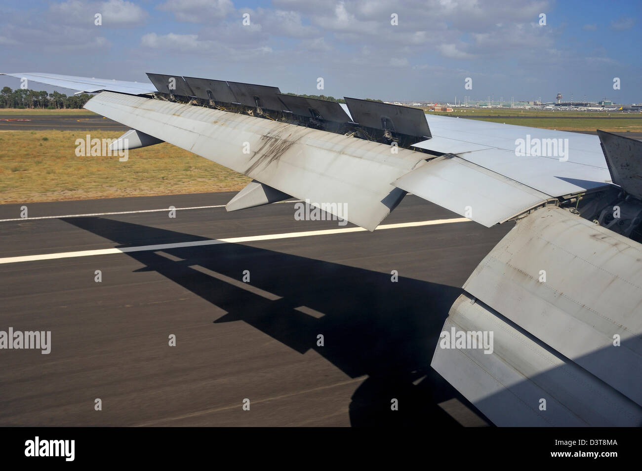 Ala de un avión aterrizando en una pista del aeropuerto Foto de stock