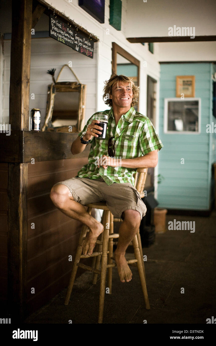 Surf dude sentados en el bar bebiendo cerveza, Santa Inés, Cornualles, en el REINO UNIDO Foto de stock