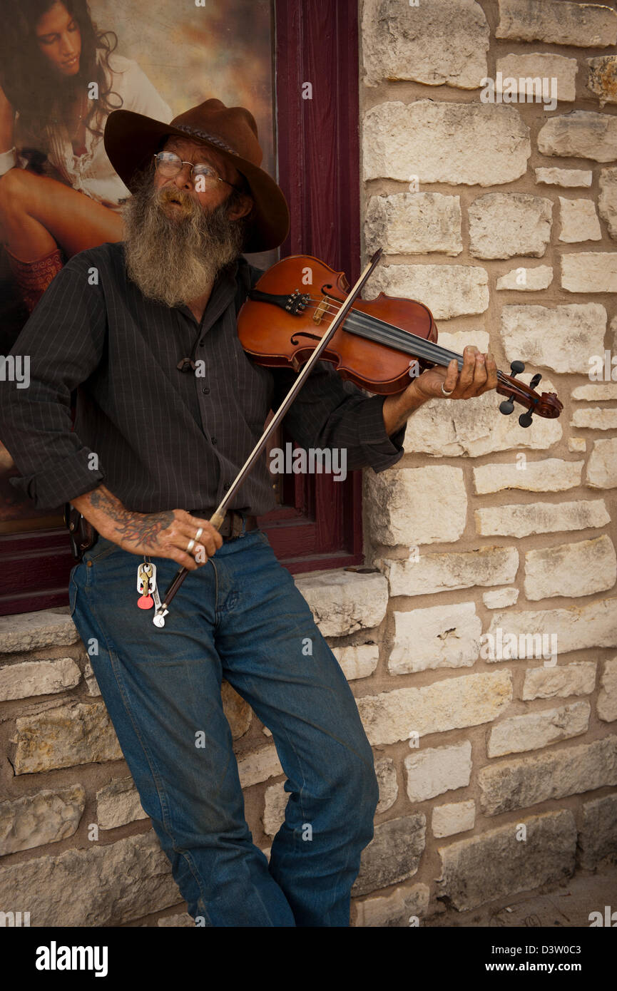 Antigua fiddler barbudo juega su violín en las calles de Austin, Texas Foto de stock