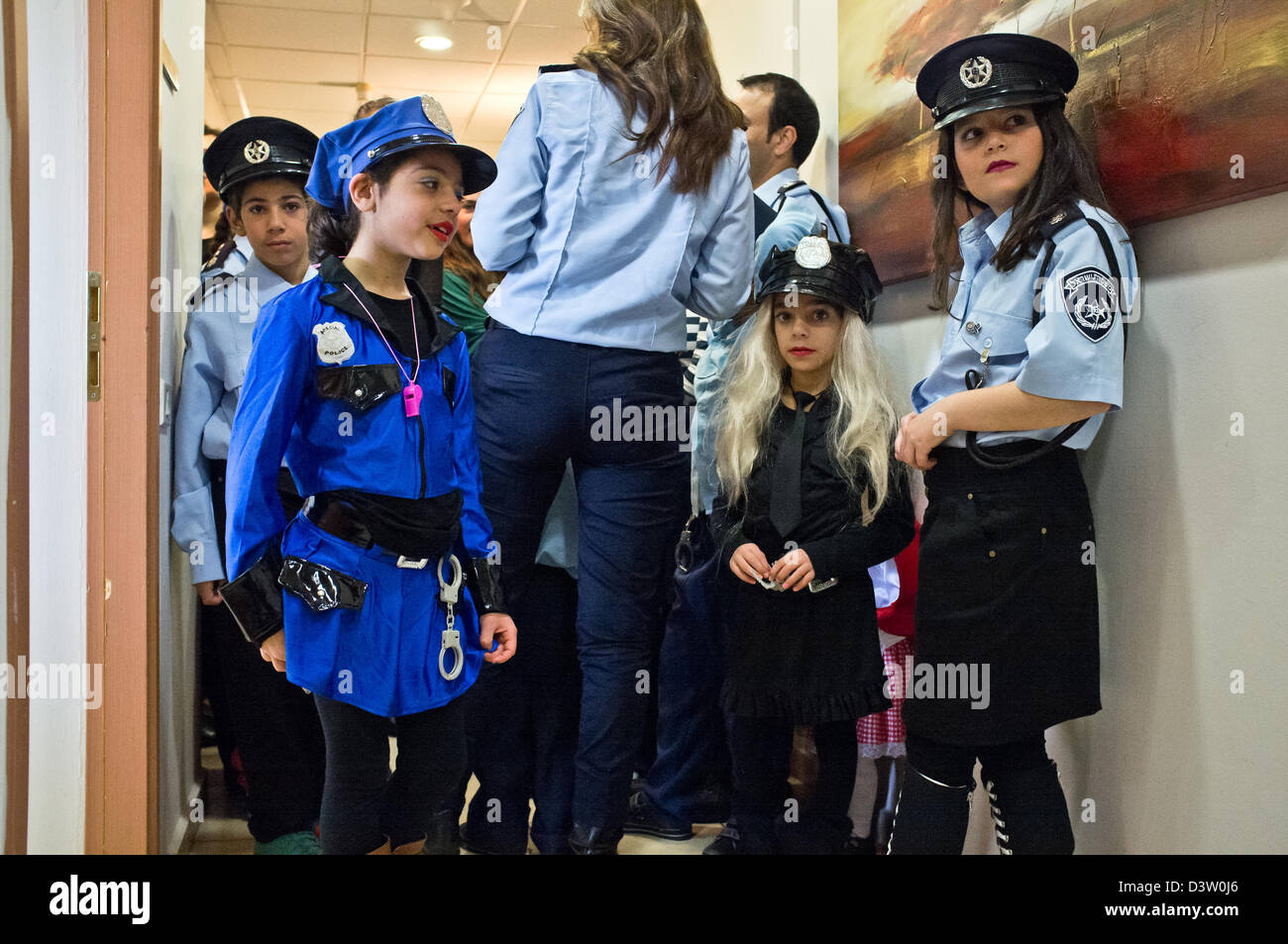 Jerusalén, Israel. 25 de febrero de 2013. Niños entusiasmados, disfrazados  de Purim como hombres y mujeres policías, esperar para entrar en el  comisario de la policía de Israel y cumplir con sala