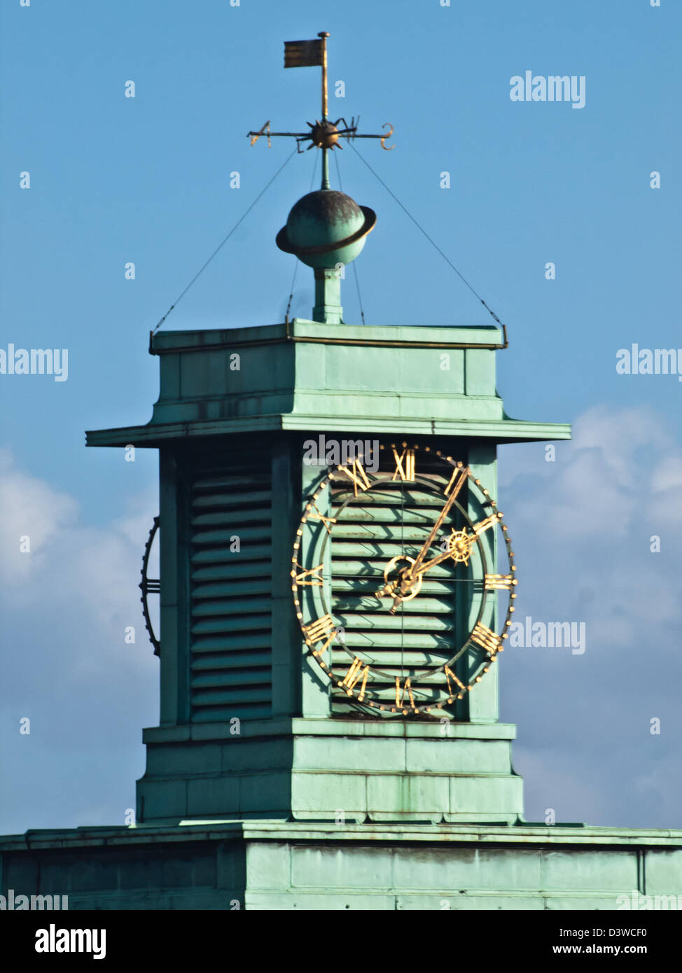 Reloj iluminado el rostro y la veleta contra un cielo azul, en Wallington, Surrey Foto de stock