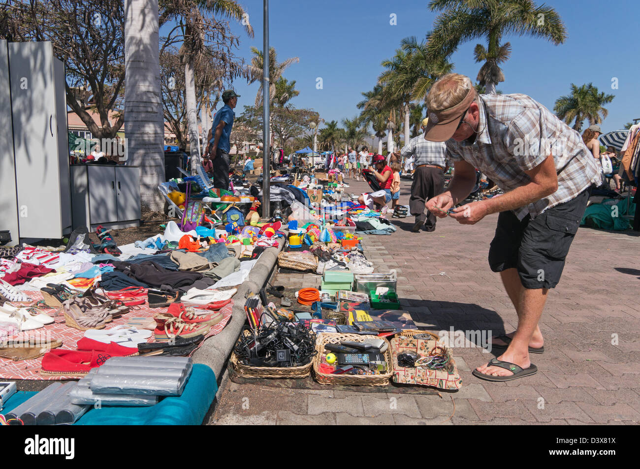 El hombre inspecciona las mercancías en el mercado de pulgas en Playa