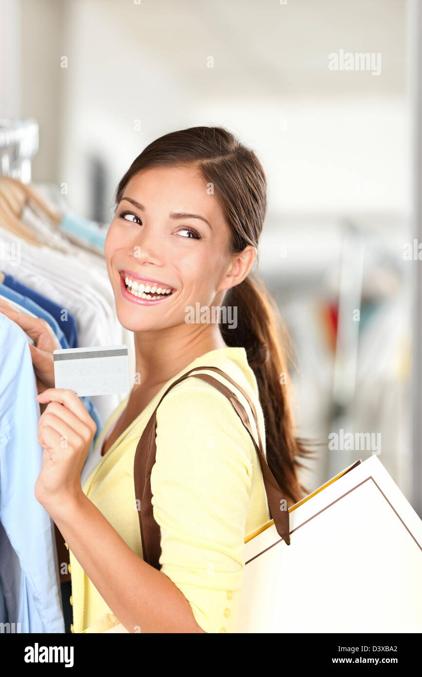 Feliz joven hermosa raza mixta Caucasain / Chino mujer asiática mostrando tarjeta de crédito en el vestido c Foto de stock