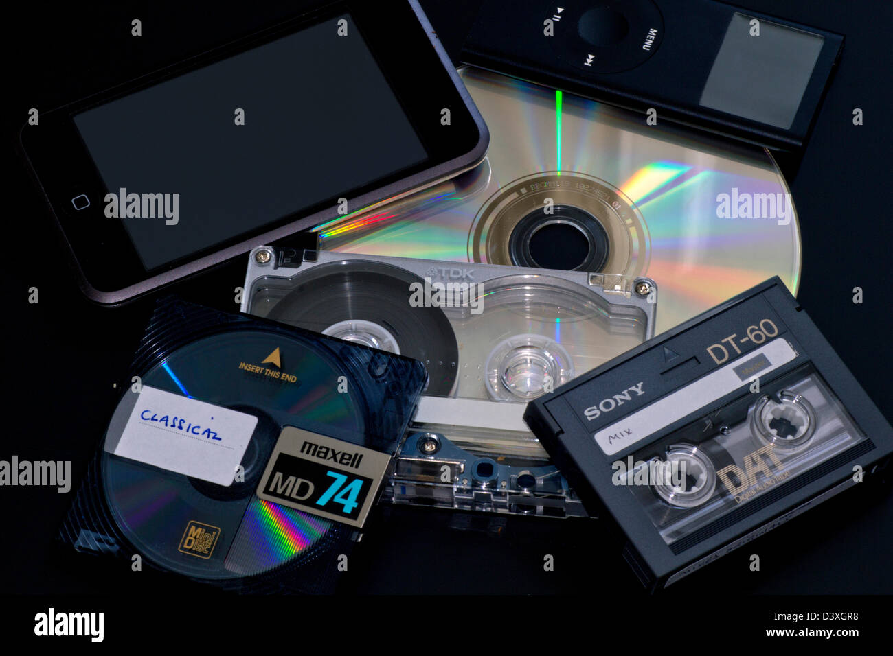 Formatos de Audio: (en el sentido de las agujas del reloj fromtop izquierda), iPod Touch, iPod Mini, un CD, una cinta de audio digital (DAT), cinta de casete (metal), MINIDISC Foto de stock