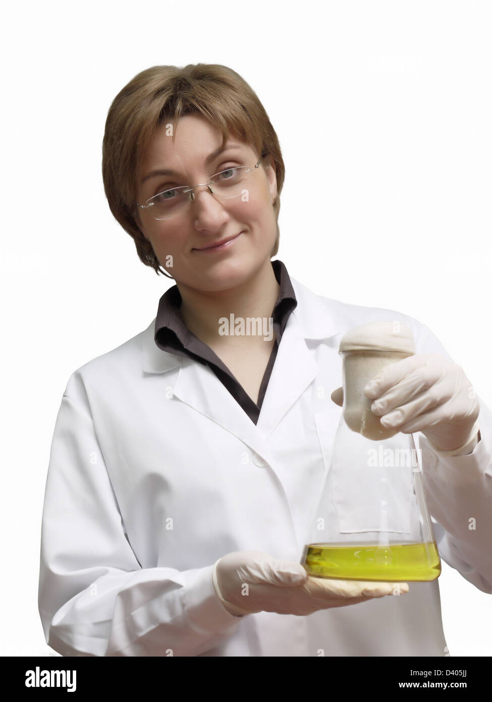 Técnico de laboratorio femenino celebración matraz erlenmeyer con la solución líquida amarilla Foto de stock