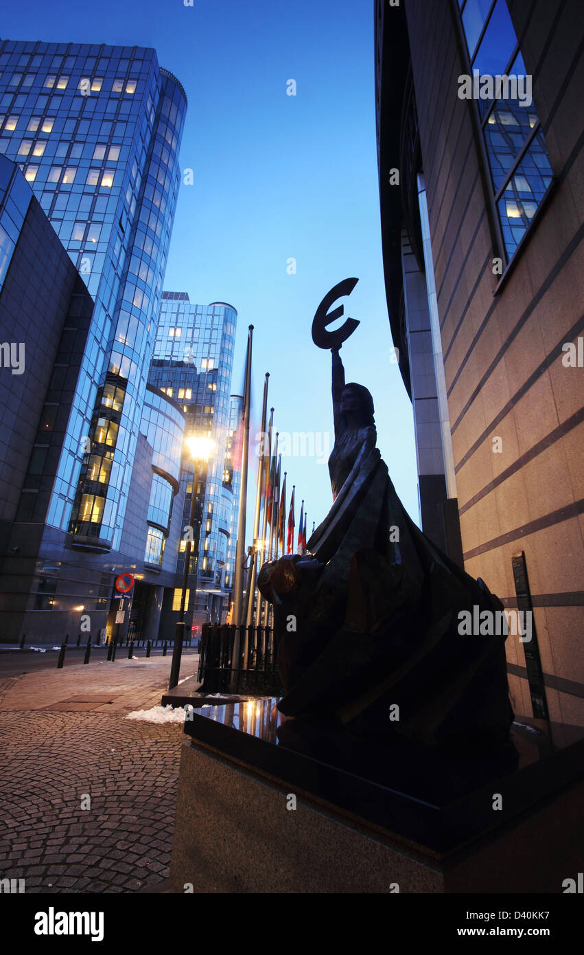 El Landmark estatua sosteniendo el símbolo del euro frente al edificio del Parlamento Europeo en Brusels (Bruselas, Bélgica). Foto de stock