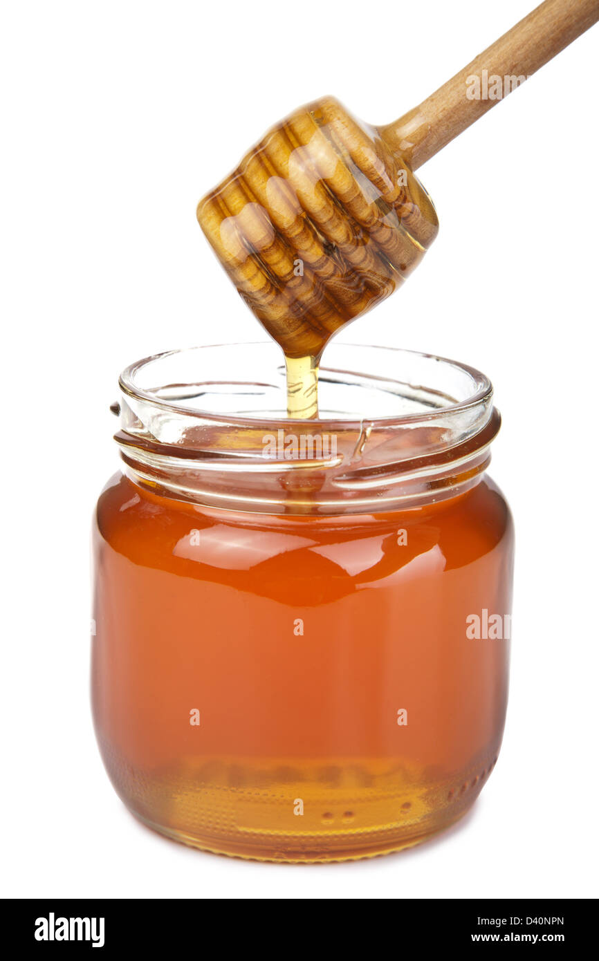 Verter la miel en tarro aislado Foto de stock