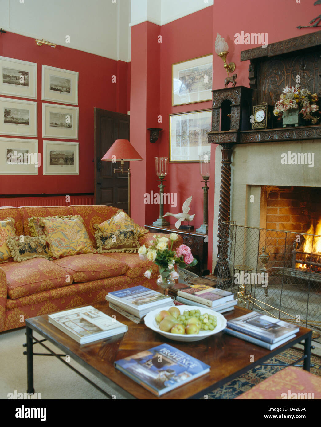 Cortinas estampadas y sillón junto a la chimenea azul con rojo cyclamen en  salon tradicional Fotografía de stock - Alamy