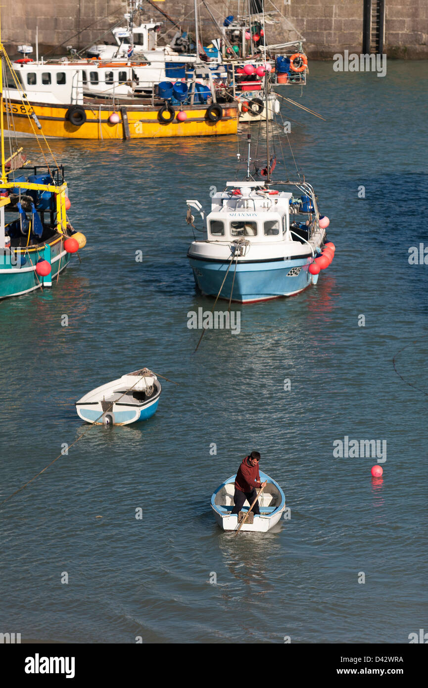 Un hombre sculling un bote en el puerto de Newquay. Foto de stock