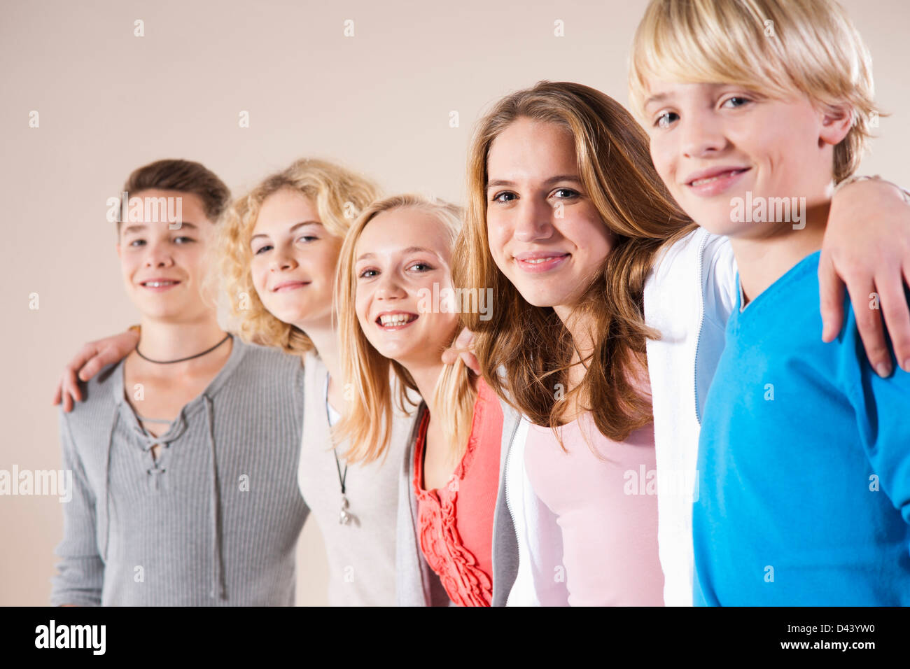 Retrato de un grupo de adolescentes, chicos y chicas, de pie en una fila  con los brazos alrededor de los hombros, Foto de Estudio sobre fondo blanco  Fotografía de stock - Alamy