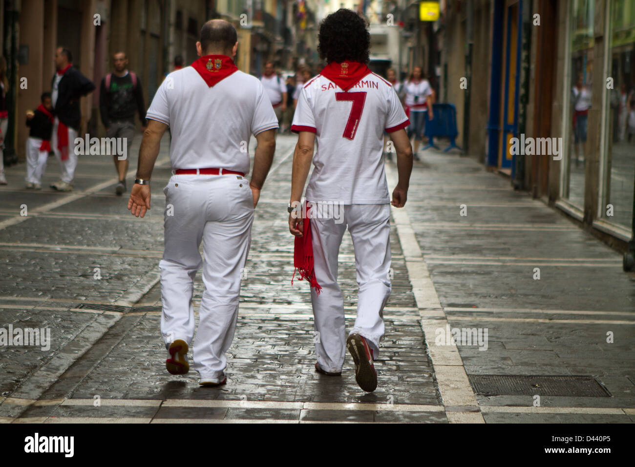 Los hombres jóvenes caminan por las calles de Pamplona vestida con el  tradicional rojo y blanco ropa durante San Fermín. Pamplona Fotografía de  stock - Alamy