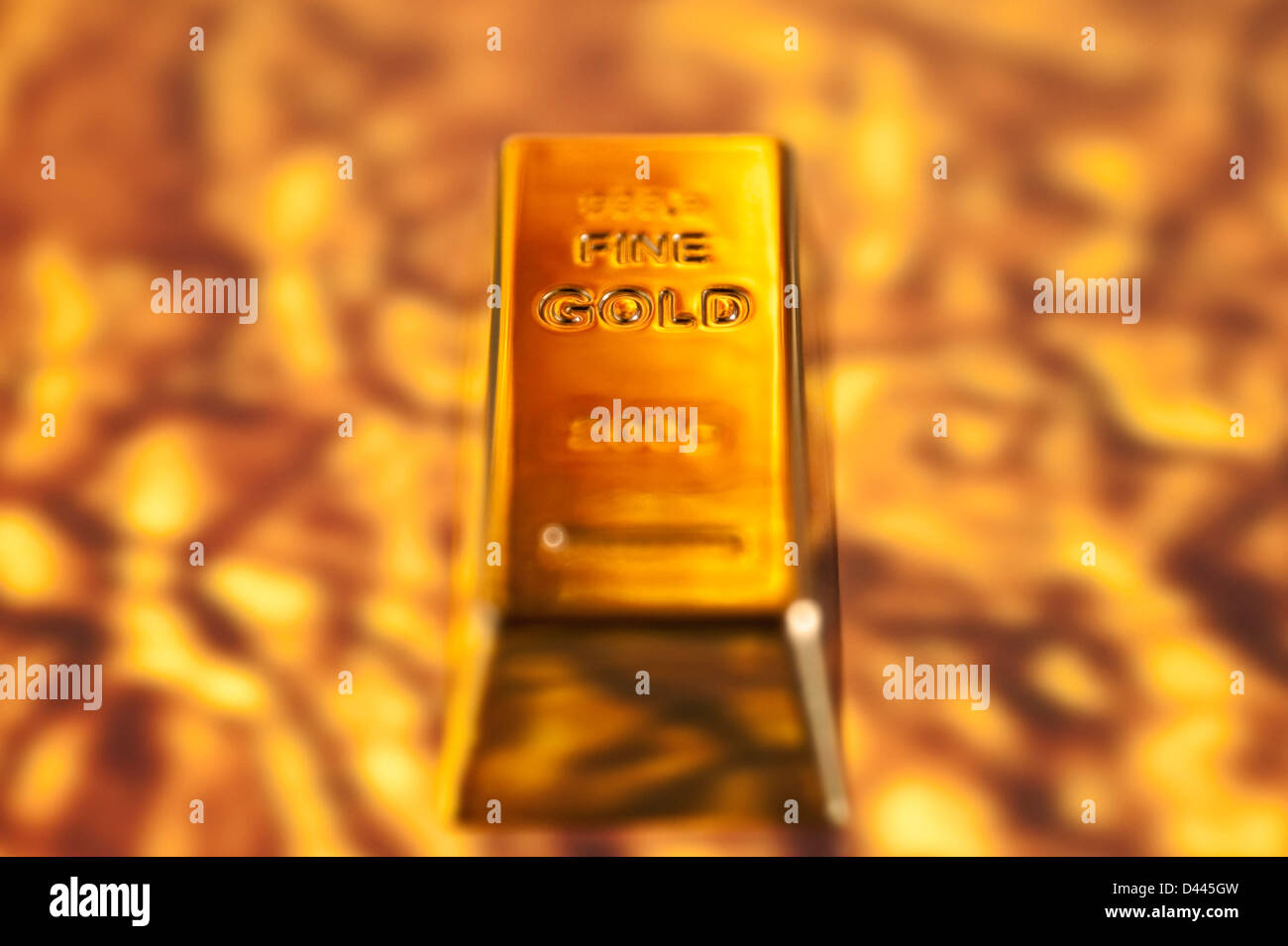 Barra de oro sobre un fondo de oro fundido. Foto de stock