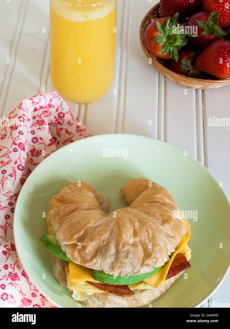 Croissant sándwich de desayuno con zumo de naranja en el desayuno. Foto de stock