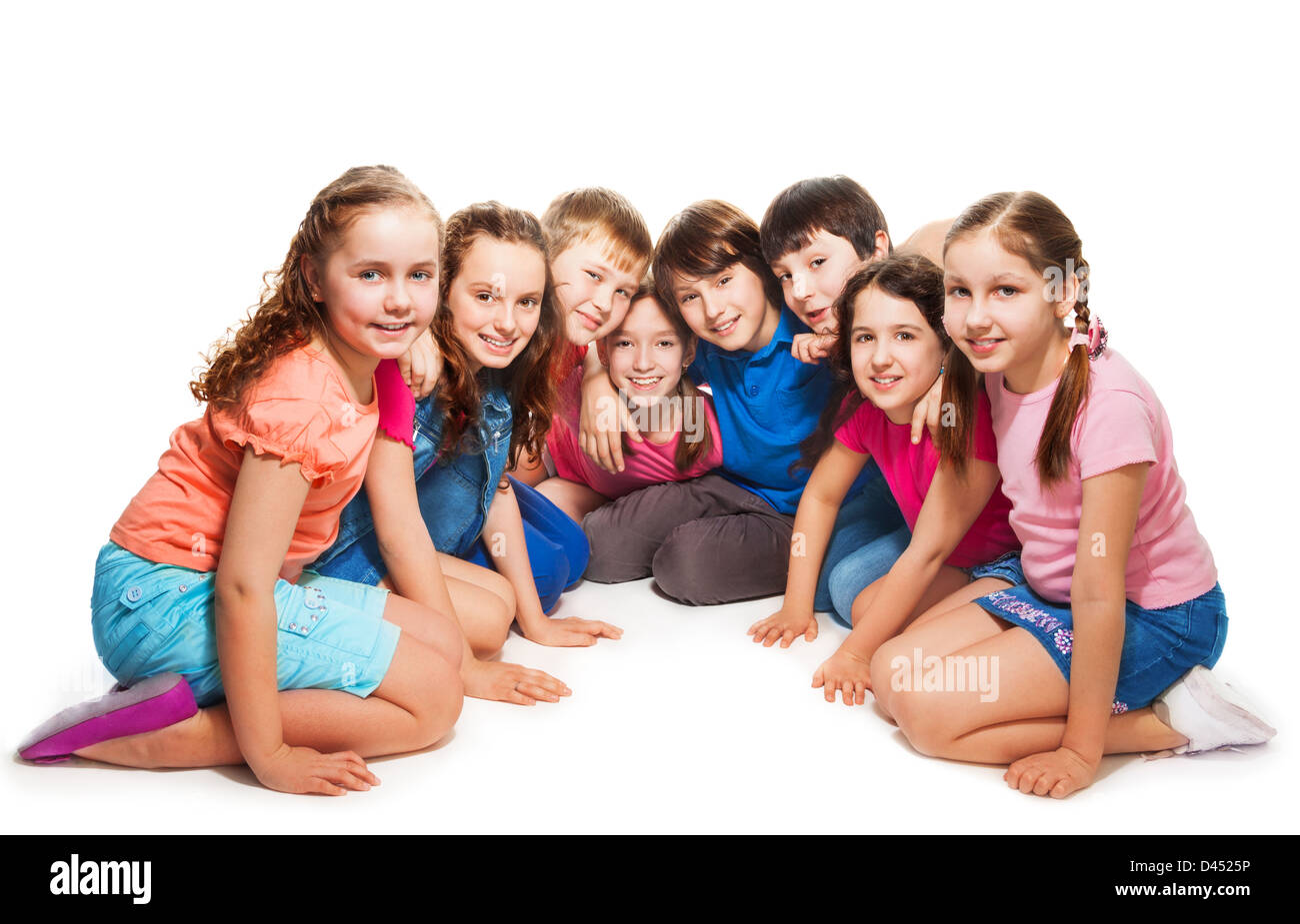 Grupo de feliz de 10 años de edad Niños y niñas sentados juntos en semi-círculo Foto de stock