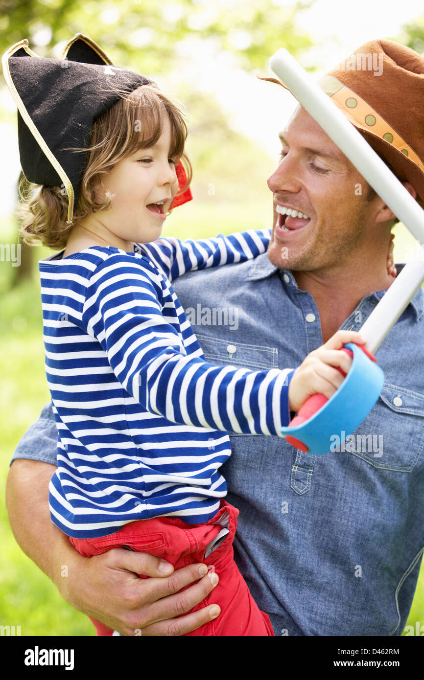 Padre jugando emocionante juego de aventura con hijo en verano de campo Foto de stock