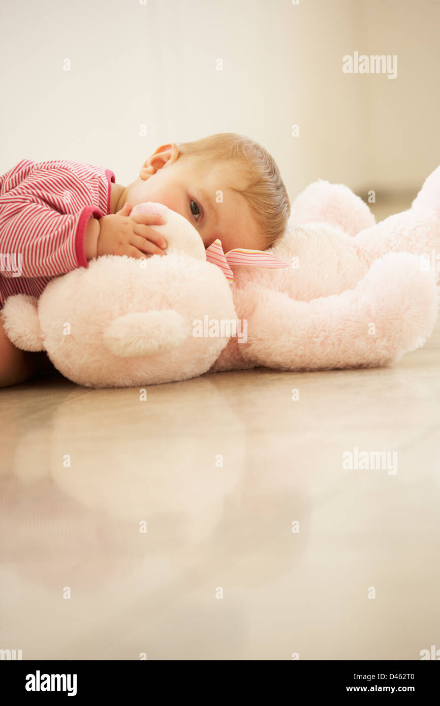 Abrazos de bebé niña osito rosa en casa Foto de stock