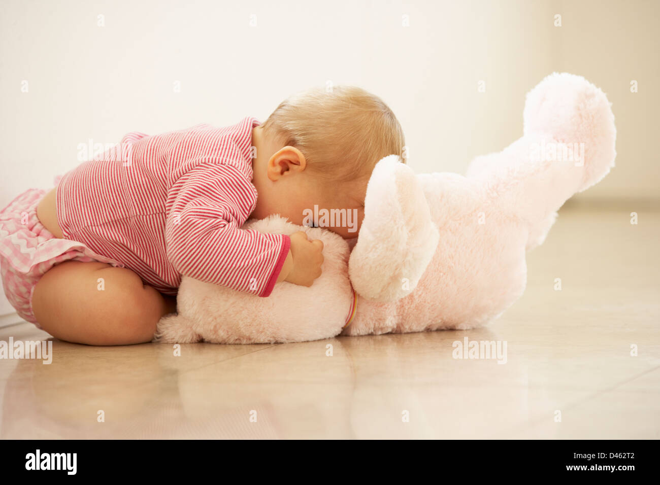 Abrazos de bebé niña osito rosa en casa Foto de stock