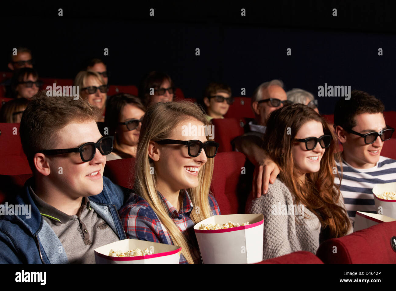 Grupo de adolescentes amigos viendo películas en 3D en el cine. Foto de stock