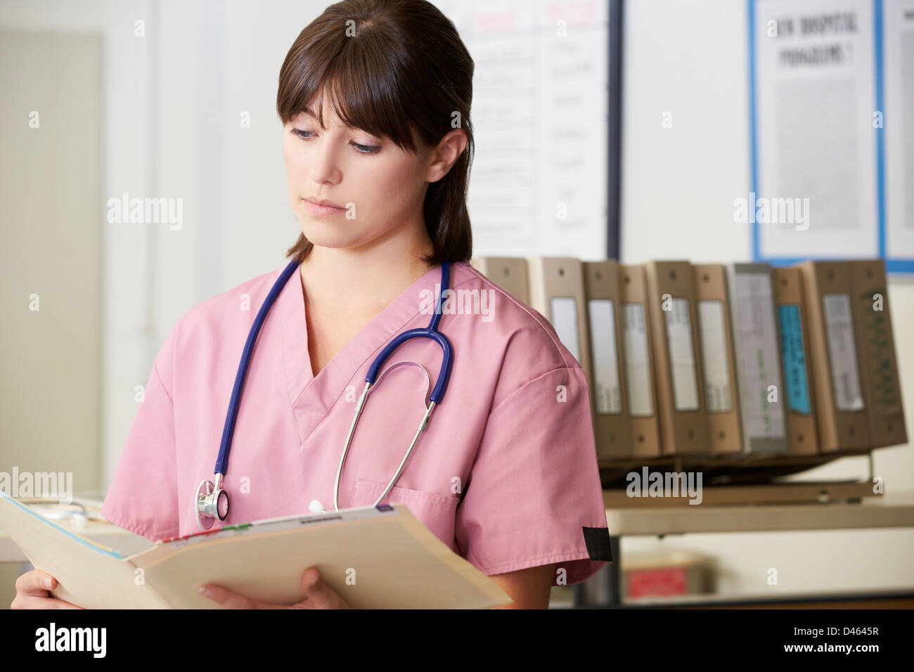 Enfermera leer las notas del paciente en el centro de enfermería Foto de stock