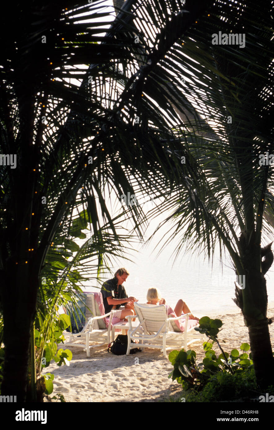 Una pareja se relaja en una playa tranquila en Little Palm Island Resort, un breve paseo en barco desde Little Torch Key en los Cayos de la Florida, Estados Unidos. Foto de stock