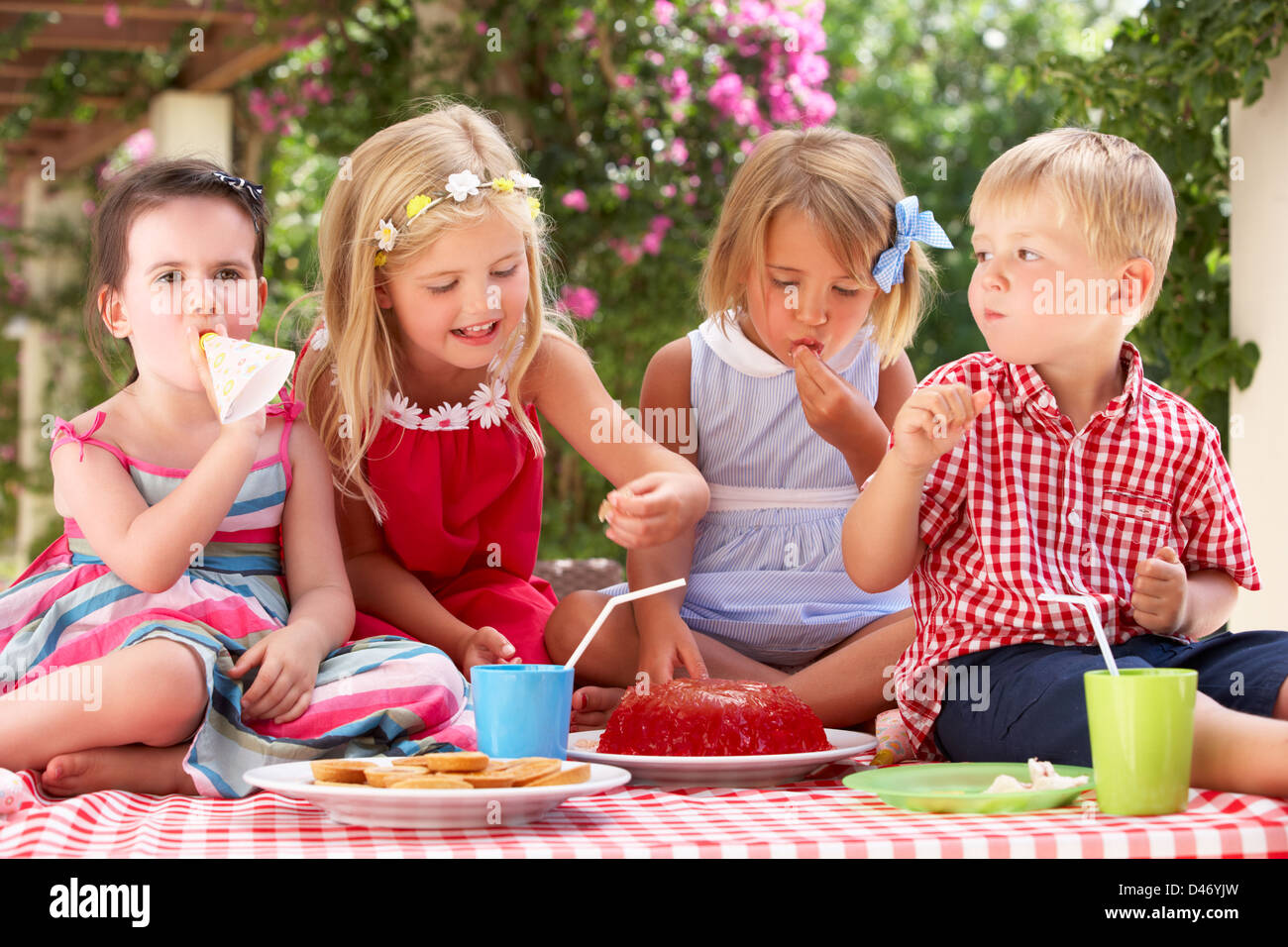 Grupo de niños comiendo jalea en Tea Party al aire libre Foto de stock