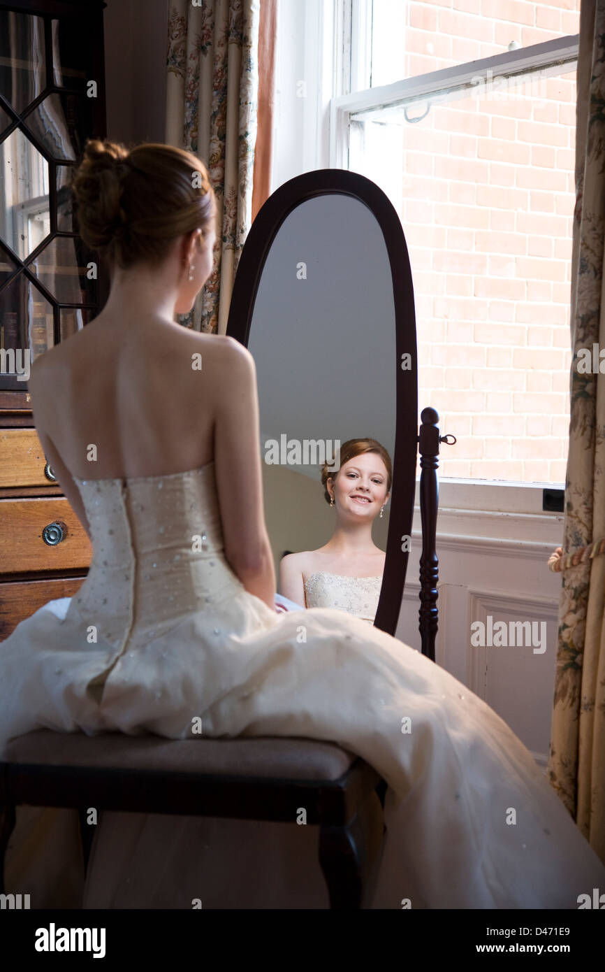 Volver ver reflejada en un espejo oval de pelo rojo de la novia vestido de novia  strapless con crema Fotografía de stock - Alamy