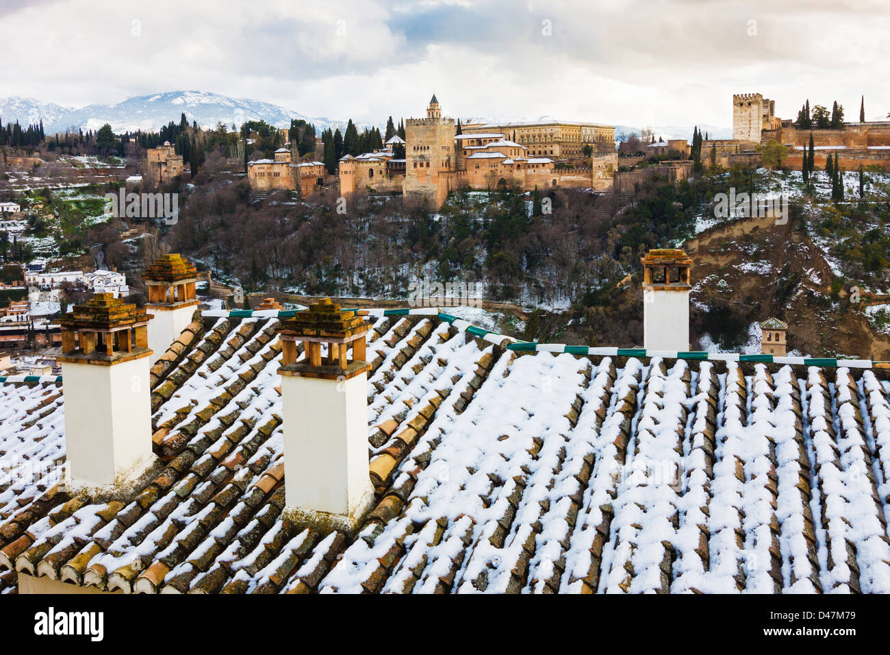 Palacio de la Alhambra, con tejados cubiertos de nieve y chimeneas en primer plano. Granada, España Foto de stock