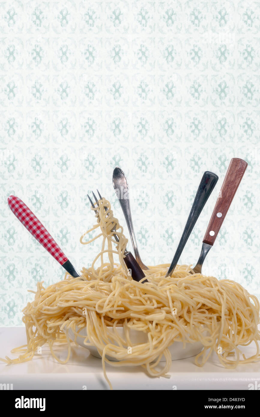 Un plato lleno de espaguetis con cinco tenedores Foto de stock