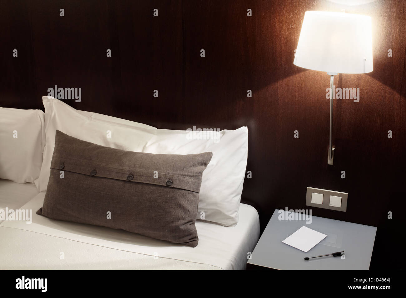 Dormitorio moderno, carta de almohadas y lámpara de noche Foto de stock