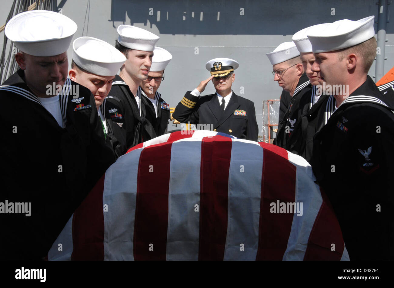 Los portadores del féretro pertenecen traer un ataúd a bordo del USS