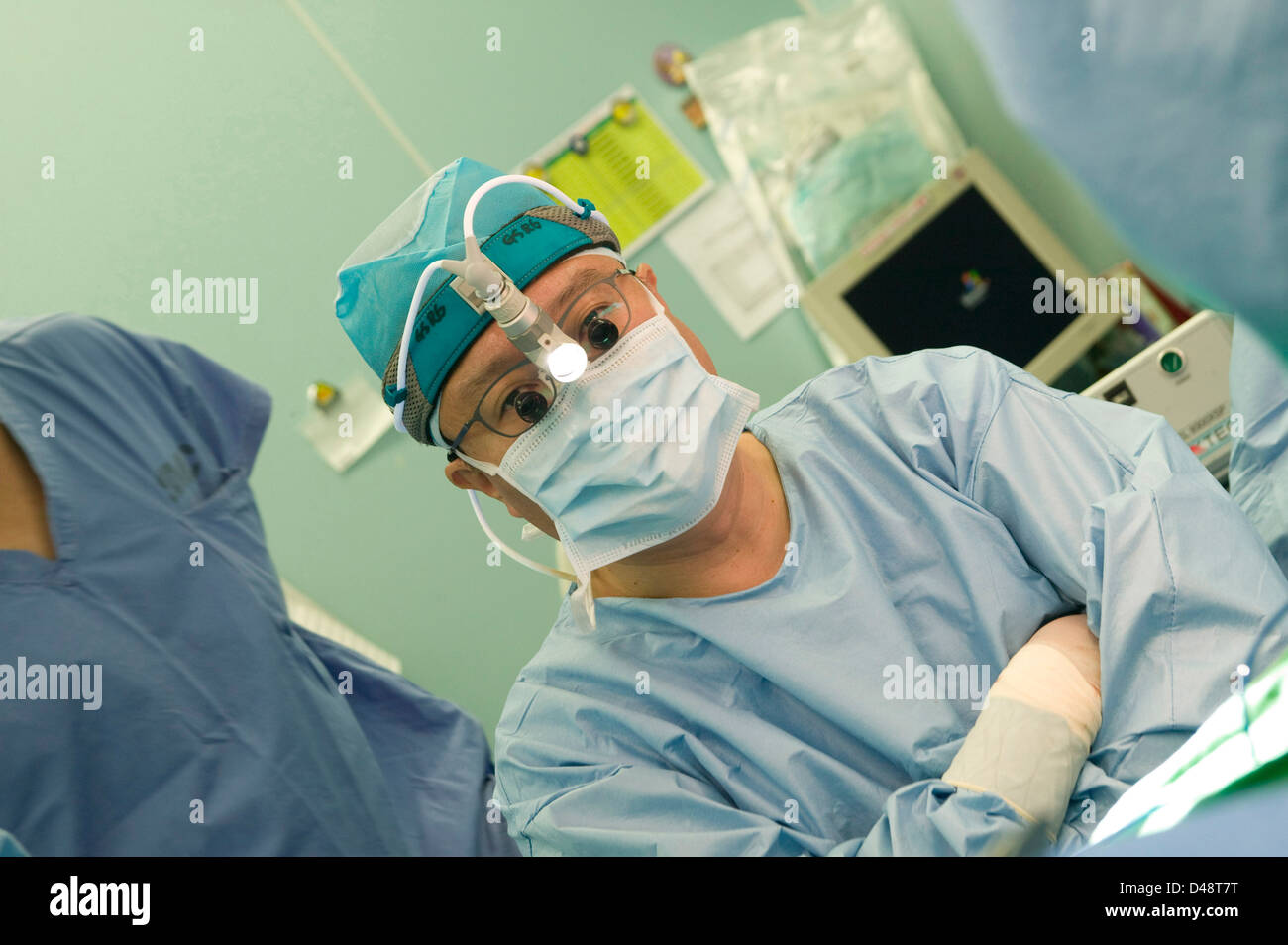 Un cirujano lleva un micro lámpara de cabeza que utiliza en su trabajo. Foto de stock