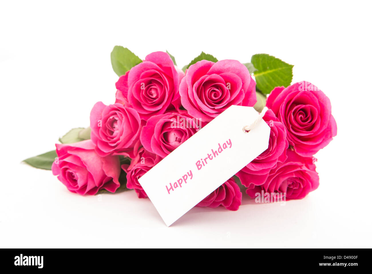 Cerca de un precioso ramo de rosas rosas con una tarjeta de cumpleaños feliz sobre un fondo blanco. Foto de stock