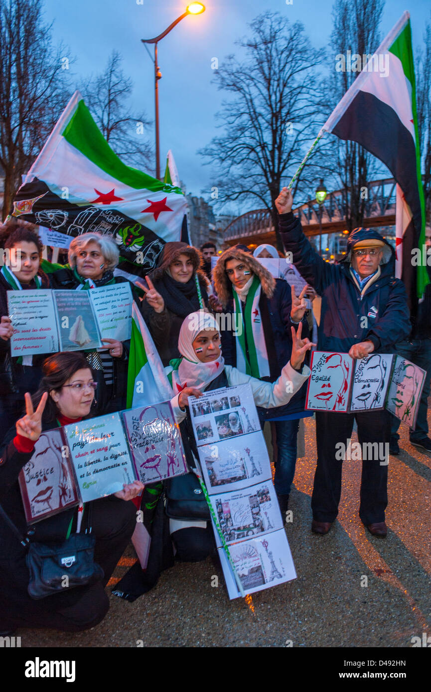 París, Francia. 8th de marzo Grupos feministas sirios que llevan a cabo señales de protesta y banderas sirias, en la manifestación anual del Día Internacional de la Mujer. marcha por los derechos de las mujeres, protestas, activismo de las mujeres Foto de stock