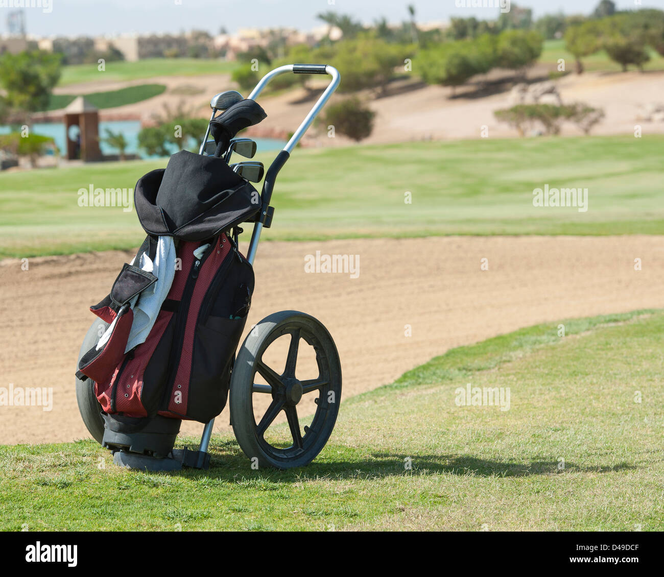 Carrito de golf trolley y la bolsa en un campo de golf con búnker en el  fondo Fotografía de stock - Alamy