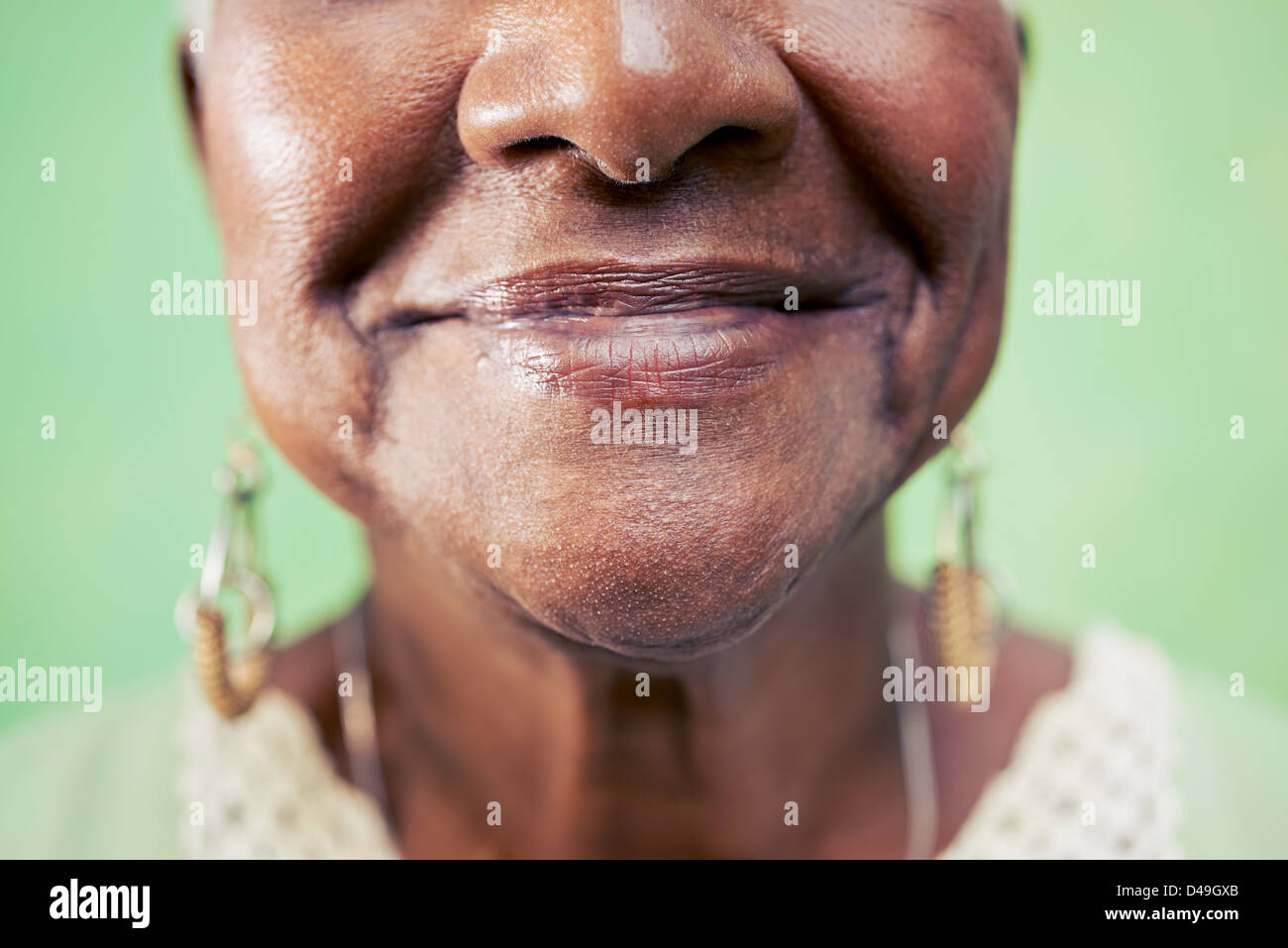 Viejo retrato de mujer negra, cerca de los ojos y de la cara sobre fondo verde. Espacio de copia Foto de stock