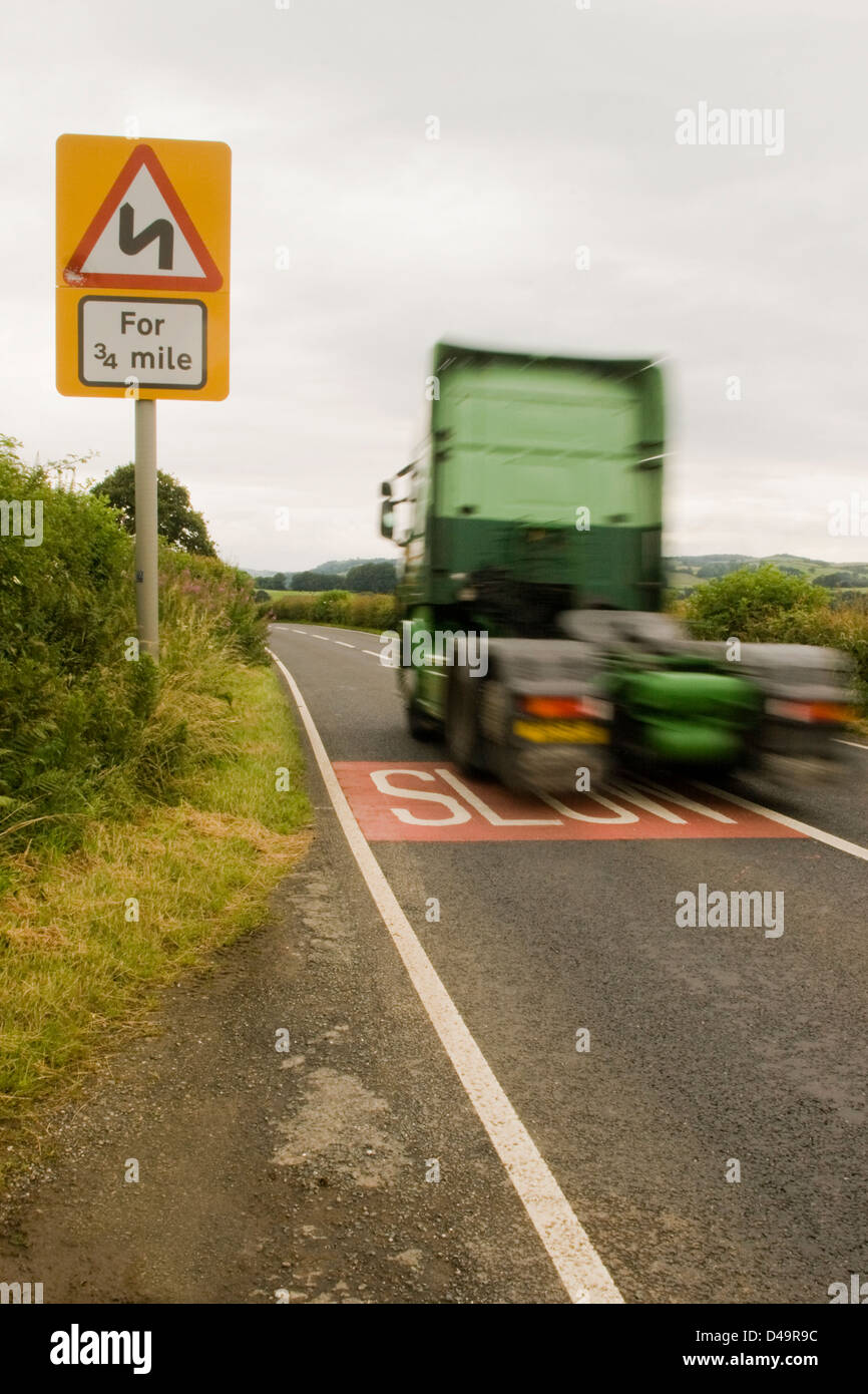 Un camión tractor viajando a la velocidad de la unidad a lo largo de una carretera rural en la campiña inglesa en el Reino Unido. Foto de stock