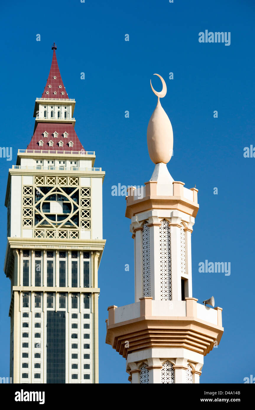 Detalle de contraste entre el minarete de la mezquita y modernos rascacielos en Dubai, Emiratos Árabes Unidos Foto de stock