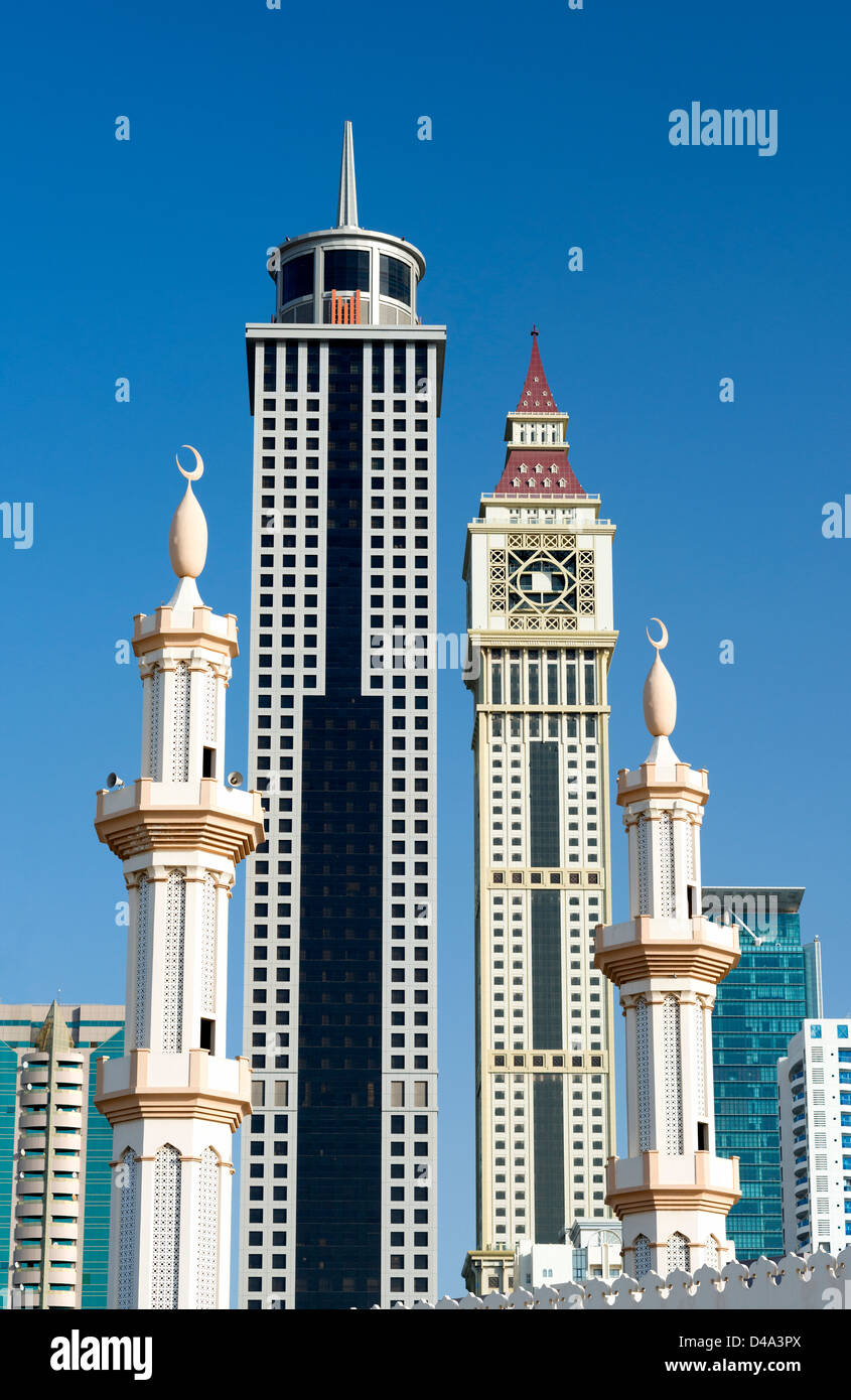 Detalle de contraste entre los minaretes de la mezquita y modernos rascacielos en Dubai, Emiratos Árabes Unidos Foto de stock