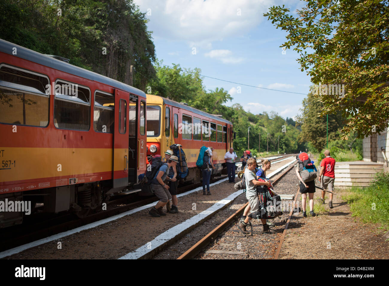 El joven alemán mochileros viajeros con mochilas dejando un tren en Szilvasvarad en Hungría Foto de stock