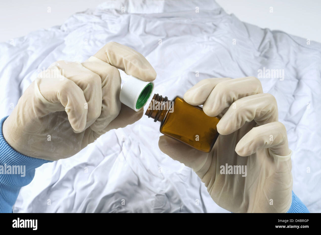 Cirujano abrir la botella del medicamento, sección intermedia Foto de stock
