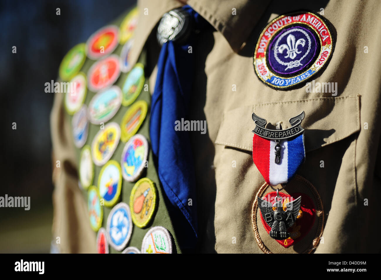 Los Boy Scouts de América cerca de un Eagle Scout con una banda llena de insignias de mérito