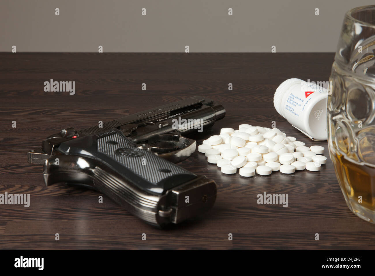 Droga, alcohol, pastillas y la pistola en la mesa. Foto de stock