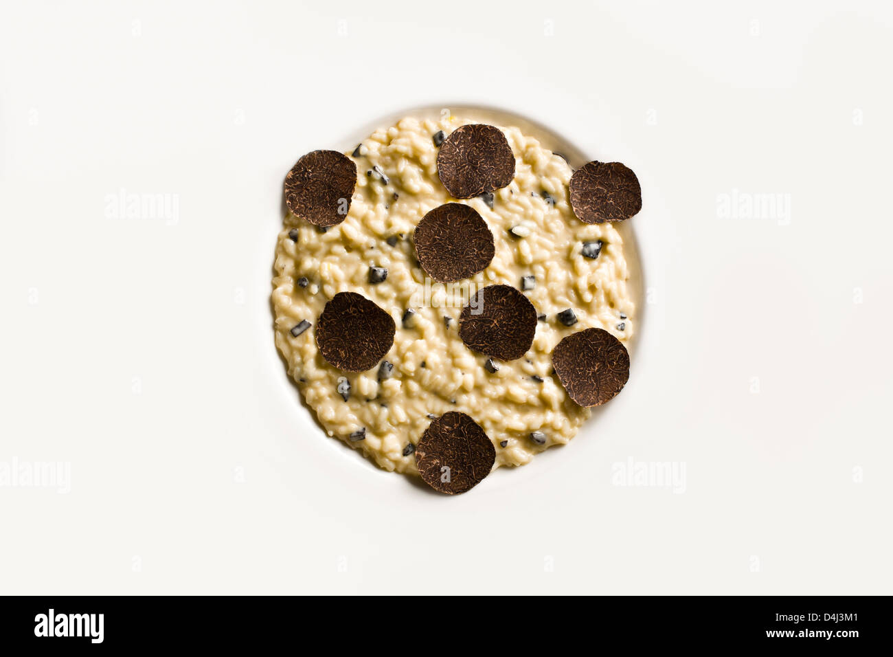 Risotto con trufa negra sobre una placa blanca. Foto de stock