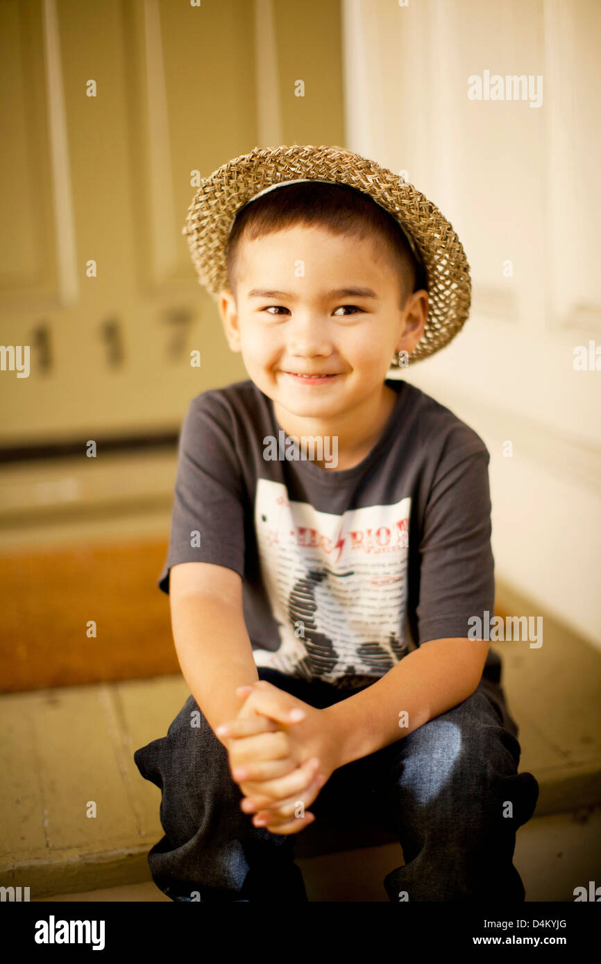 Sonriente niño usando sombrero de paja Foto de stock