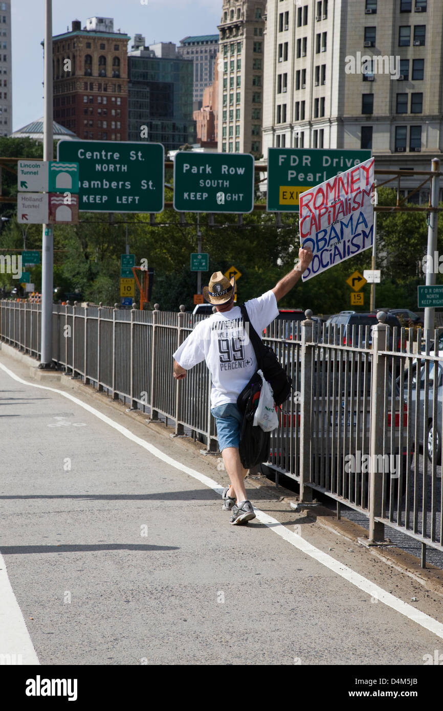 El hombre en la acera llevando un cartel de publicidad política, "Romney el capitalismo, el Socialismo de Obama" en Nueva York Foto de stock