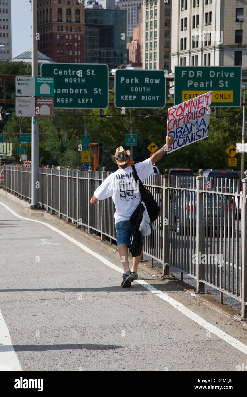 El hombre en la acera llevando un cartel de publicidad política, "Romney el capitalismo, el Socialismo de Obama" en Nueva York Foto de stock