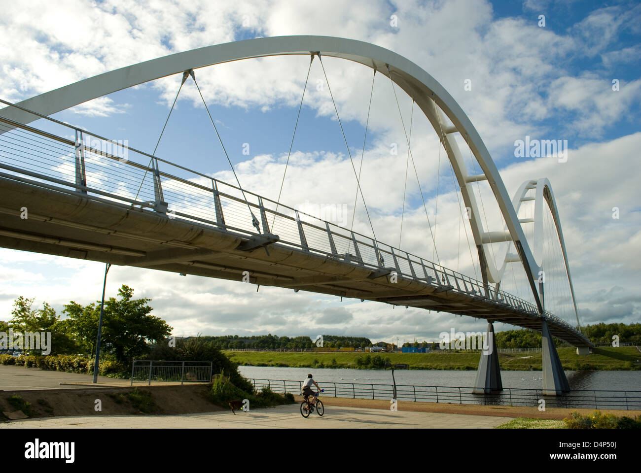 Un joven monta su bicicleta bajo el puente Infinito, Stockton on Tees, Cleveland, REINO UNIDO Foto de stock