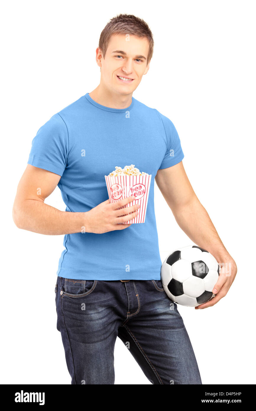 Los deportes masculinos sosteniendo un fútbol y caja de palomitas de maíz aislado sobre fondo blanco. Foto de stock